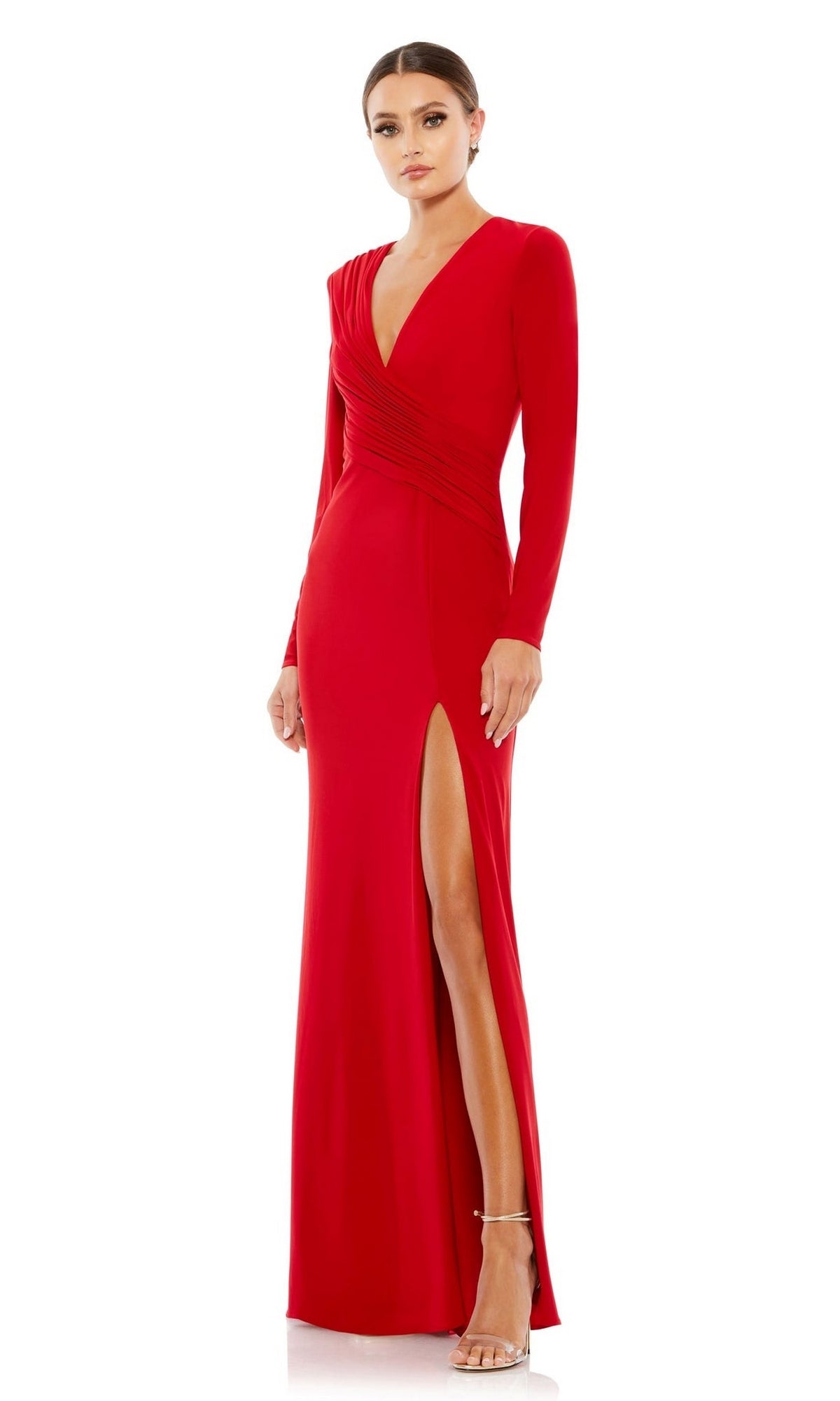 A woman wearing the Mac Duggal 26686 long sleeve long formal dress—a red floor-length v-neck evening gown with a deep slit—stands against a white background.